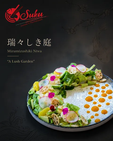 Minimal dish feature for Suku showing a garden salad with lotus root and edible flowers on dark slate